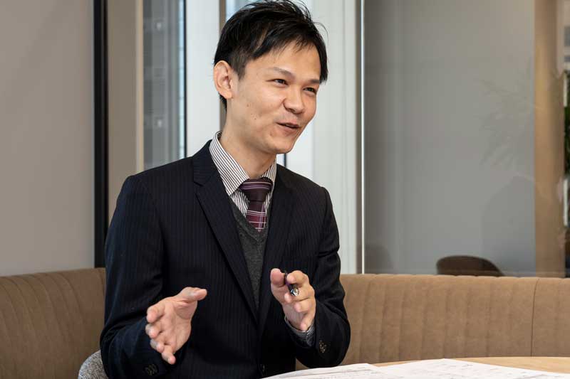テーブル越しに話す柿間さん